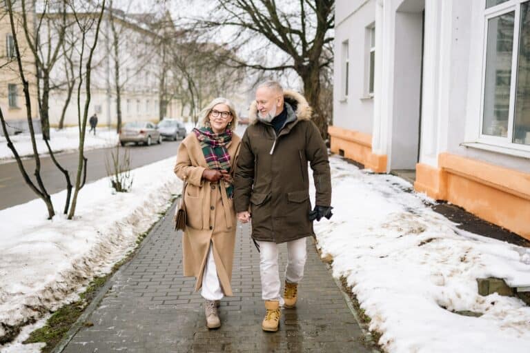 Man and woman walking down street during winter